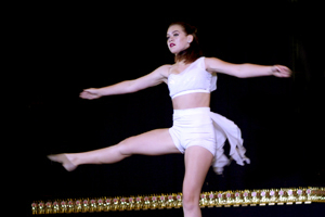 Dancer in white outfit on stage at competition